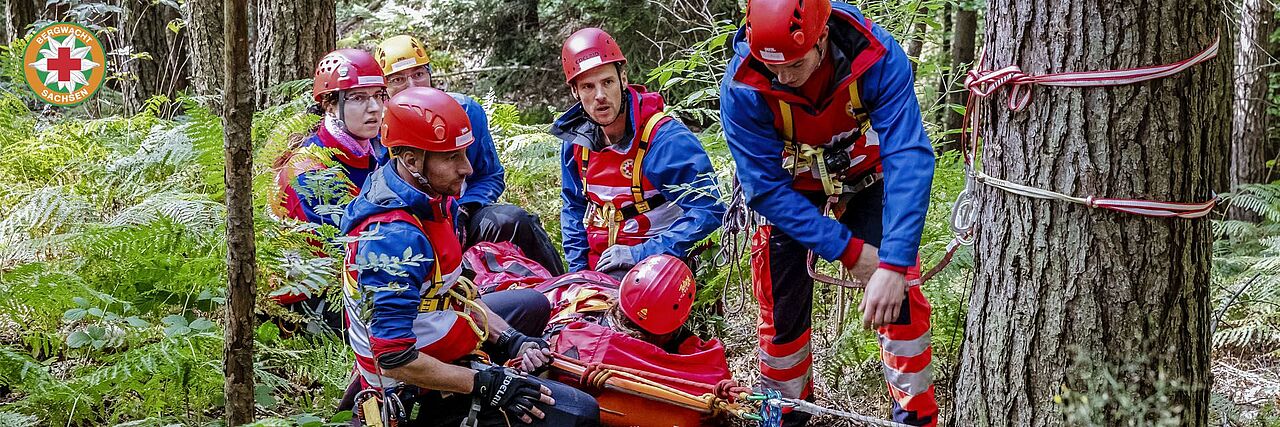 Bergretter versorgen eine Person im Wald.